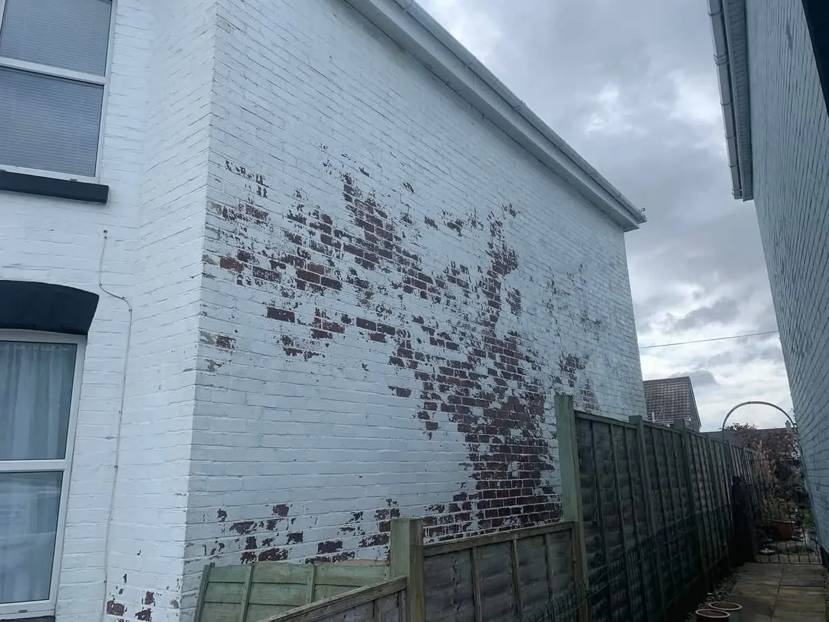 Peeling paint on a brick wall before redecoration in Polzeath
